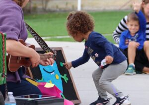 child on playground placing object on felt board